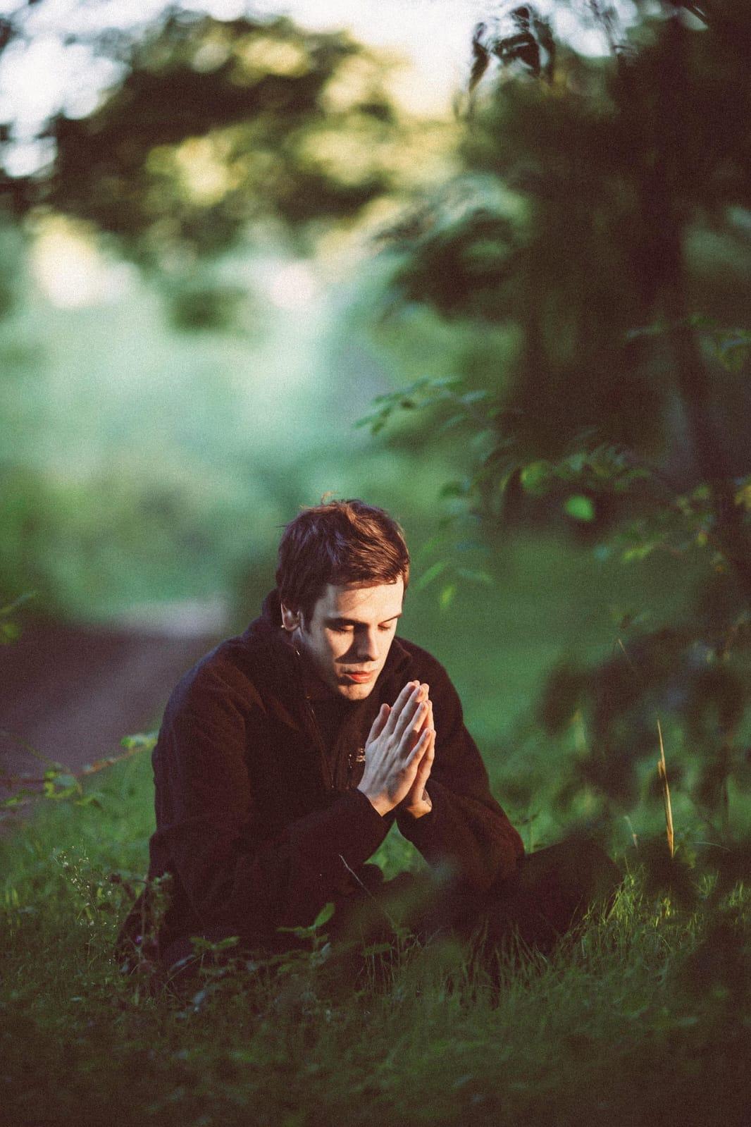 A person sits quietly with hands folded in a moment of stillness